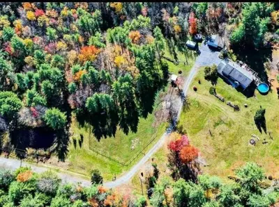 an aerial view of a house with a truck in a park at Southwoods Mountain Estate -private mansion, pool, hottub+ 15 acres in Monticello