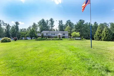 a house with an american flag in a field at Southwoods Mountain Estate -private mansion, pool, hottub+ 15 acres in Monticello
