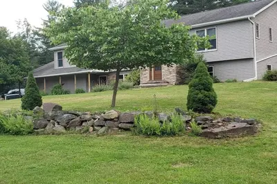 a stone retaining wall in front of a house at Southwoods Mountain Estate -private mansion, pool, hottub+ 15 acres in Monticello