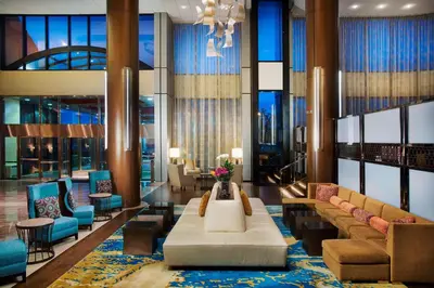 a lobby with a couch and a table and chairs at Teaneck Marriott at Glenpointe in Teaneck
