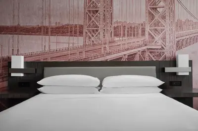 a bed with white pillows in front of a bridge at Teaneck Marriott at Glenpointe in Teaneck