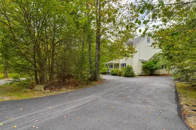 an empty road in front of a house with trees at Fire Pit and Hot Tub Peaceful Poconos Farms Getaway in Tobyhanna