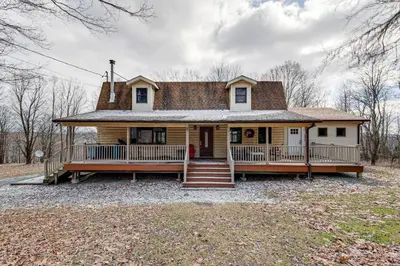 an old house with a porch and stairs in front at 2 Mi to Elk Mountain Poconos Escape on 11 Acres! in Pleasant Mount