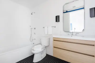 a bathroom with a toilet and a sink and a mirror at Placemakr Wall Street in New York