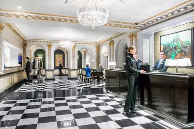 a woman standing at a counter in a lobby at The Pierre, A Taj Hotel, New York in New York