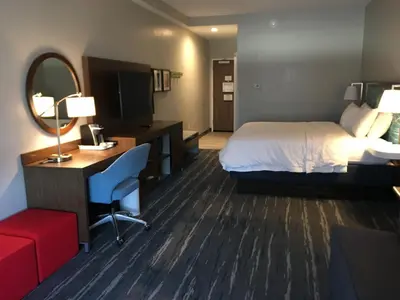a hotel room with a bed and a desk and a mirror at Hampton Inn Old Bridge NJ in Old Bridge