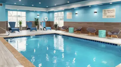 a large swimming pool in a hotel room with chairs at Hampton Inn Old Bridge NJ in Old Bridge