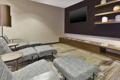 a waiting room with chairs and a flat screen tv at Courtyard by Marriott Secaucus Meadowlands in Secaucus