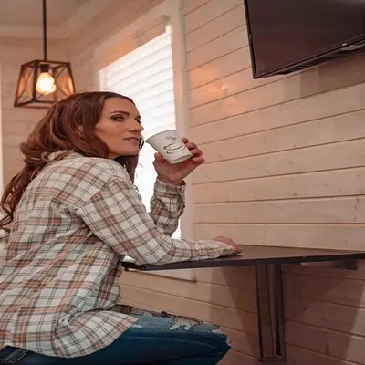 a woman sitting at a table holding a remote control at Camptel Poconos in Albrightsville