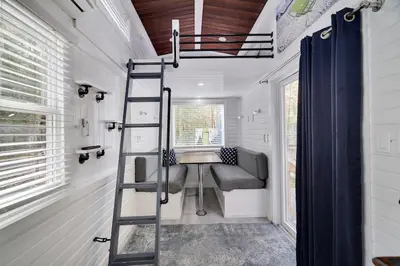 a tiny house with a ladder and a couch at Camptel Poconos in Albrightsville