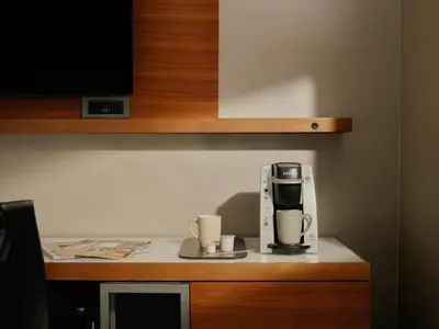 a coffeemaker and two coffee cups sitting on a counter at The Cloud One New York-Downtown, by the Motel One Group in New York