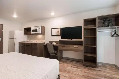 a hotel room with a bed and a desk with a television at WoodSpring Suites Philadelphia Northeast in Philadelphia