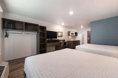 a hotel room with two beds and a desk at WoodSpring Suites Philadelphia Northeast in Philadelphia