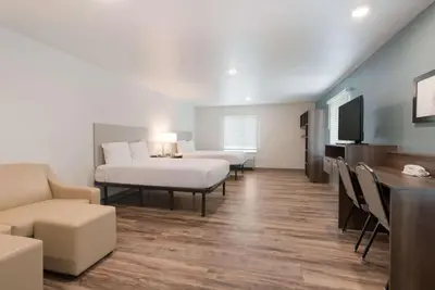 a room with two beds and a table and chairs at WoodSpring Suites Philadelphia Northeast in Philadelphia