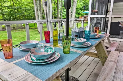 a wooden picnic table with plates and glasses on it at Relax Fireside! Retreat 15 Mi to Camelback Slopes in Tobyhanna