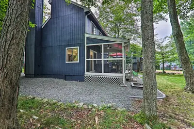 a black house with a large window and trees at Relax Fireside! Retreat 15 Mi to Camelback Slopes in Tobyhanna