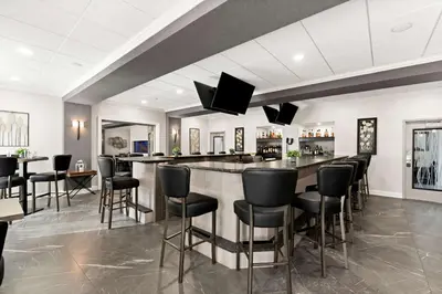 a bar in a restaurant with black bar stools at Best Western Plus Concordville Hotel in Concordville