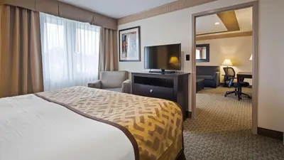 a hotel room with a bed and a flat screen tv at Best Western Plus Concordville Hotel in Concordville