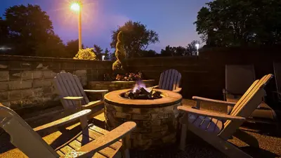 a group of chairs sitting around a fire pit at night at Best Western Plus Concordville Hotel in Concordville