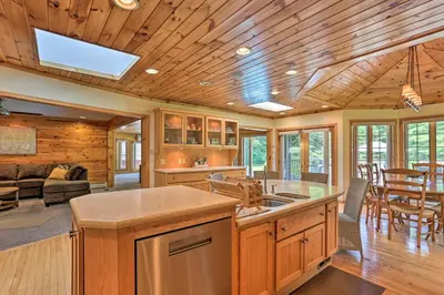 a kitchen and living room with a table and chairs at Riverside Retreat in Catskill Mountains with Pool, Hot Tub & Game Room in Starlight