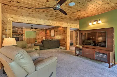 a living room with a couch and a flat screen tv at Riverside Retreat in Catskill Mountains with Pool, Hot Tub & Game Room in Starlight