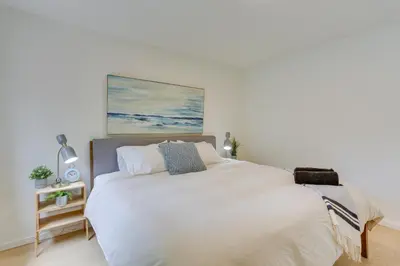 a bedroom with a white bed with a painting on the wall at Cozy Swan Lake Apt with Grill and Private Yard in Swan Lake