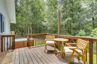 a porch with two chairs and a table on a deck at Cozy Swan Lake Apt with Grill and Private Yard in Swan Lake