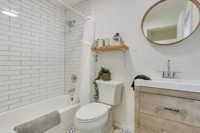 a bathroom with a toilet and a sink and a mirror at Cozy Swan Lake Apt with Grill and Private Yard in Swan Lake