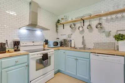 a kitchen with blue cabinets and white appliances at Cozy Swan Lake Apt with Grill and Private Yard in Swan Lake