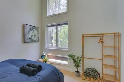 a bedroom with a blue bed and a window at Charming Swan Lake Apartment with Deck! in Swan Lake
