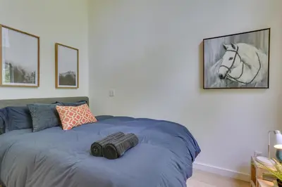 a bedroom with a bed with a horse picture on the wall at Charming Swan Lake Apartment with Deck! in Swan Lake