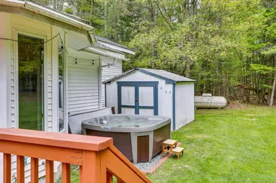 a bath tub sitting in the yard next to a house at Charming Swan Lake Apartment with Deck! in Swan Lake