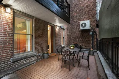 a patio with a table and chairs on a brick wall at The Historic Blue Moon Hotel - NYC in New York