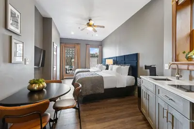 a bedroom with a bed and a table and a kitchen at The Historic Blue Moon Hotel - NYC in New York
