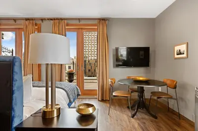 a hotel room with a bed and a table and a tv at The Historic Blue Moon Hotel - NYC in New York