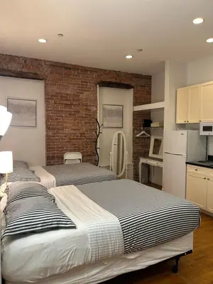 a bedroom with two beds and a brick wall at Hansem stay near Empire State Building in New York