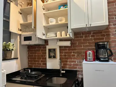 a kitchen with a sink and a brick wall at Hansem stay near Empire State Building in New York