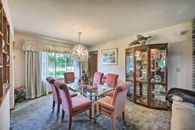 a dining room with a glass table and pink chairs at 12 Mi to Hersheypark Family Home with Deck! in Harrisburg
