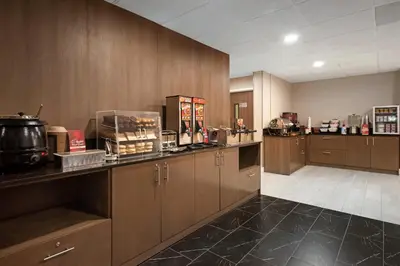a kitchen with wooden cabinets and a counter top at Best Western Plus Meadowlands in Secaucus
