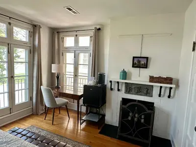 a living room with a fireplace and a table and chair at City House Bed and Breakfast in Harrisburg