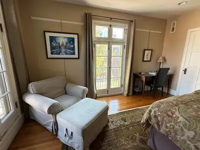 a bedroom with a bed and a chair and a desk at City House Bed and Breakfast in Harrisburg