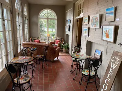 a living room with tables and chairs and a fireplace at City House Bed and Breakfast in Harrisburg