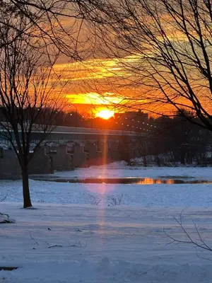 a sunset over a snowy field with the sun setting at City House Bed and Breakfast in Harrisburg