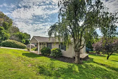 a small house with a tree in the yard at Family-Friendly Coatesville House with Fire Pit in Coatesville