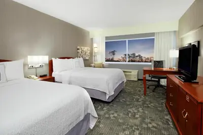 a hotel room with two beds and a flat screen tv at Courtyard by Marriott Lyndhurst/Meadowlands in Lyndhurst