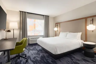 a hotel room with a bed and a desk and a window at Fairfield by Marriott Inn & Suites Rockaway in Rockaway