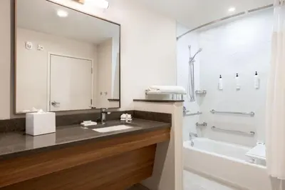 a bathroom with a sink and a tub and a mirror at Fairfield by Marriott Inn & Suites Rockaway in Rockaway