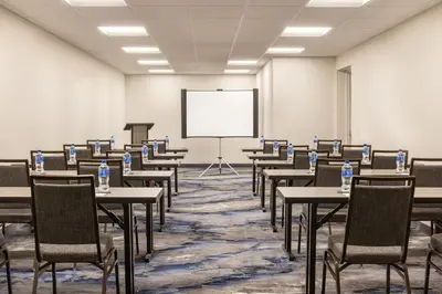 an empty room with tables and chairs and a whiteboard at Fairfield by Marriott Inn & Suites Rockaway in Rockaway
