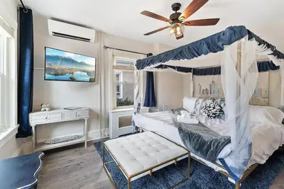 a bedroom with a canopy bed and a ceiling fan at King,Parking,AC,Deck,Train,Uni,Hospital in Bryn Mawr