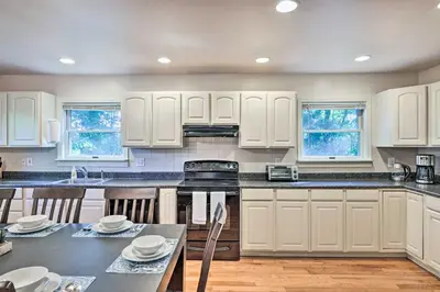 a kitchen with white cabinets and a table with chairs at Hot Tub and Yard Stroudsburg Home in Poconos in Stroudsburg